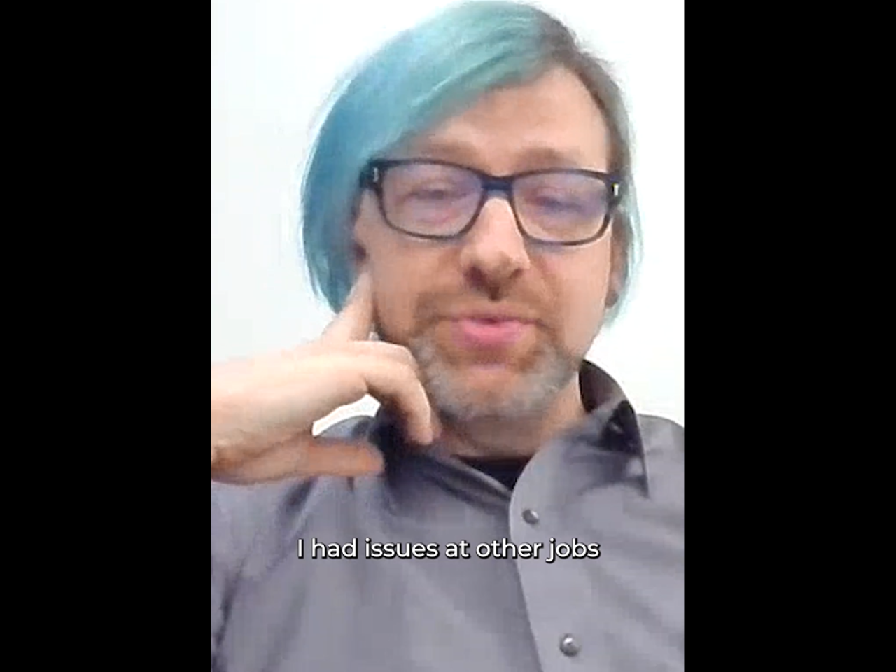 A person in glasses and a streak of light blue hair in a virtual meeting. "I had issues at other jobs."