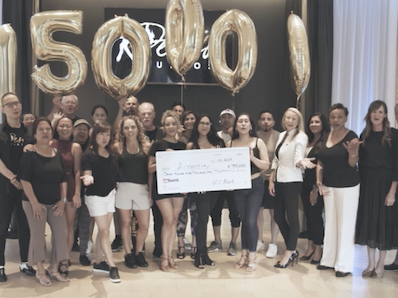 Deseo Studios receiving a $750,000 grant check from U.S. Bank.