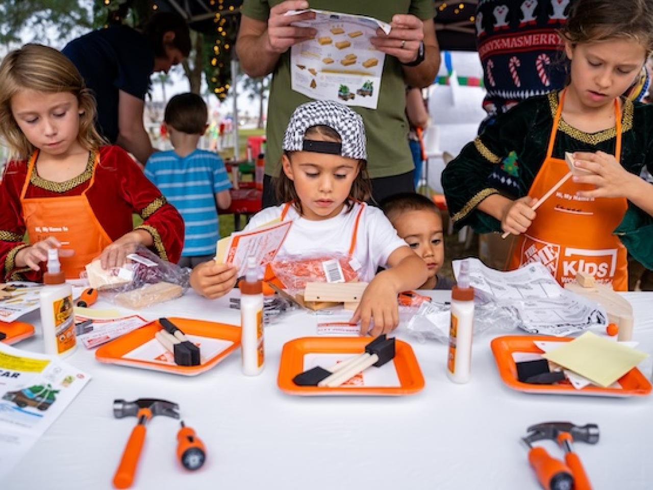 The Home Depot Kids Workshop. Kids shown at a table making crafts and gifts.