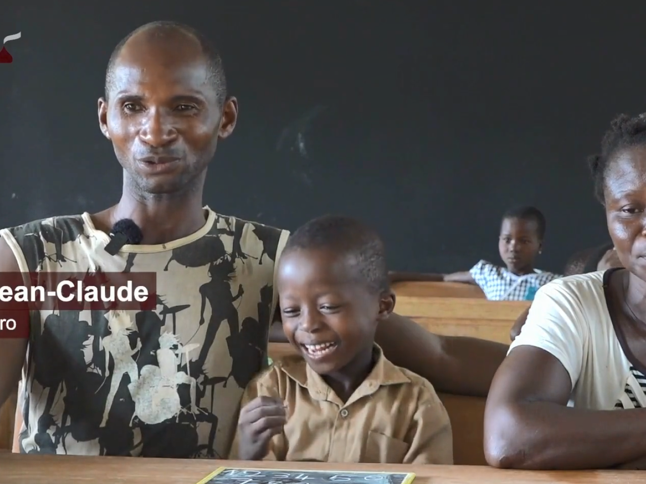 Two adults sitting with a child in a classroom.