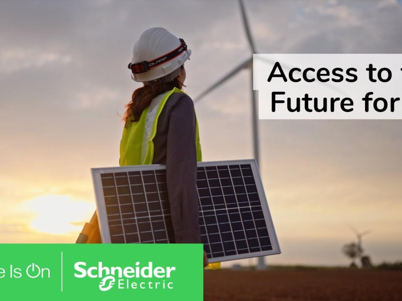 A person carrying a solar panel outside. A wind turbine in the distance. Schneider Electric logo. 