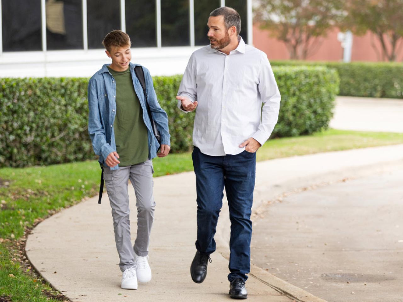 Father and son walking and having a conversation.