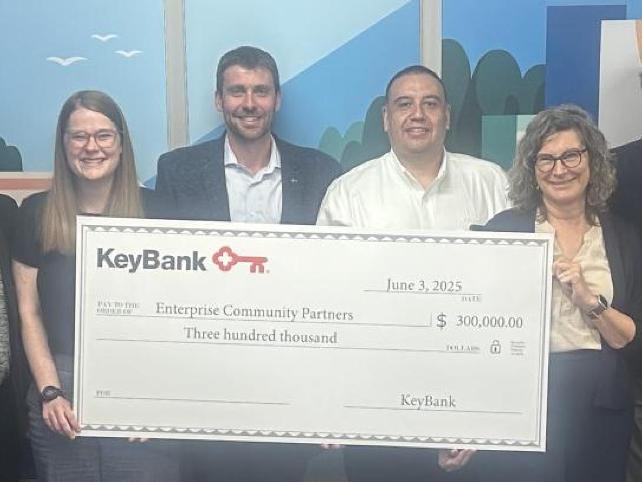 Representatives from KeyBank and Enterprise Community Partners shown with a grant check for $300,000.