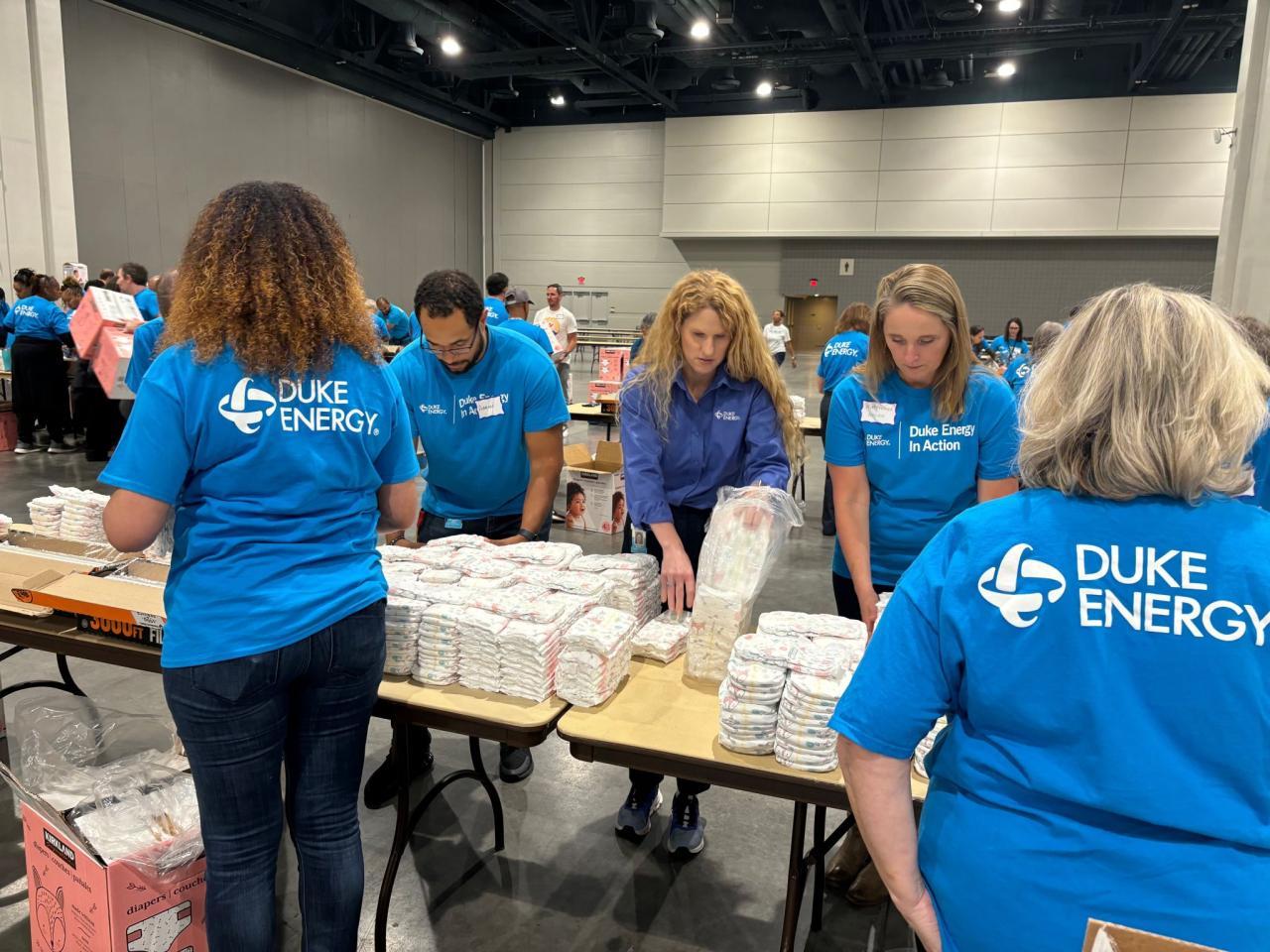 Volunteers stacking diapers at tables.