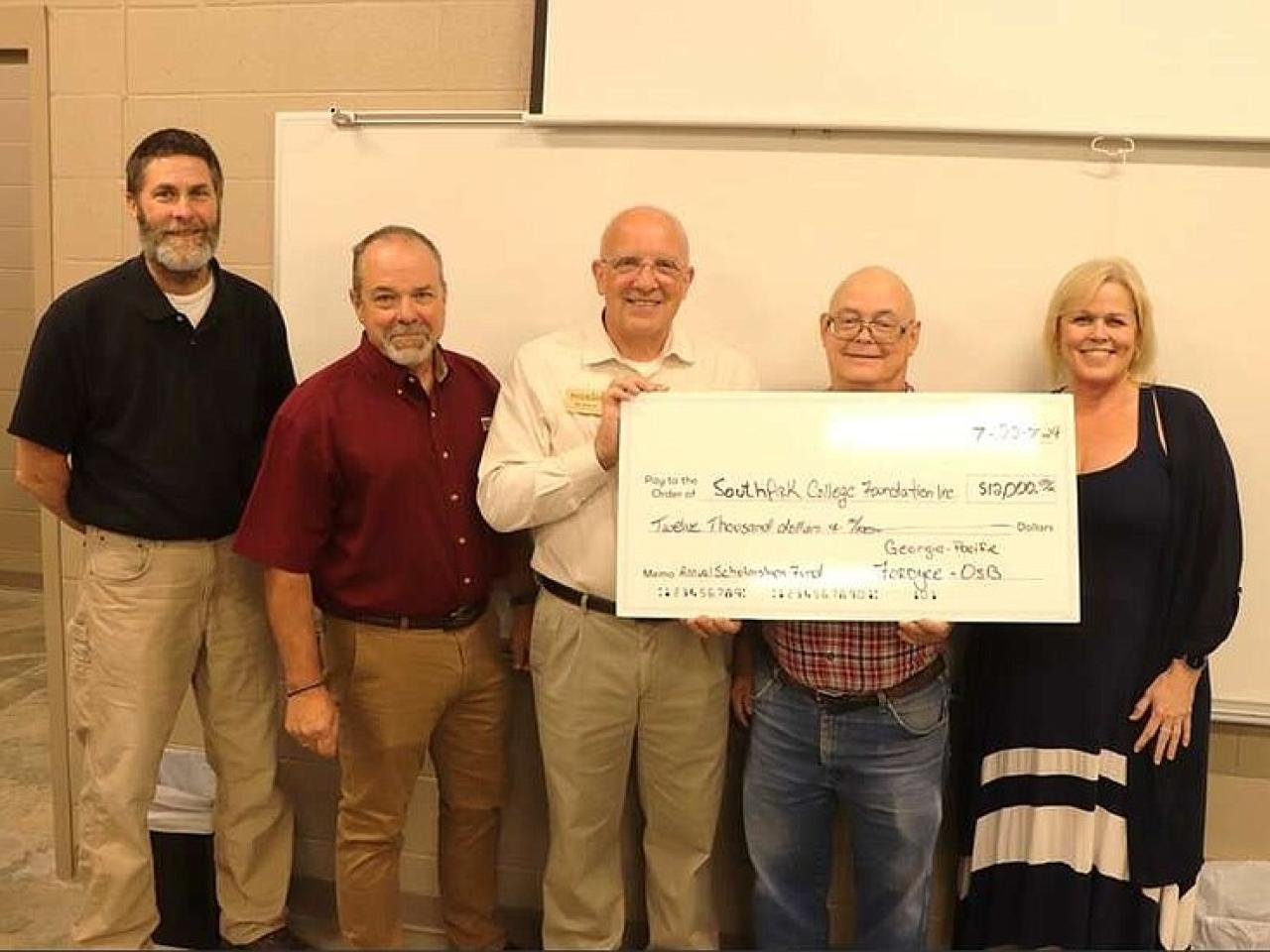 Five people holding an oversized check