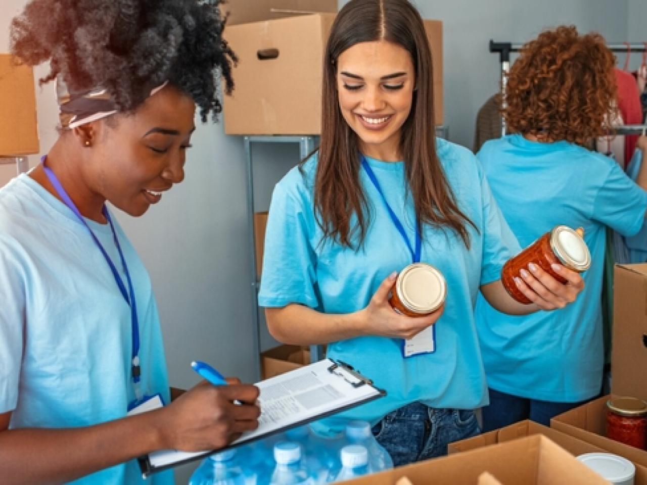 People working together, one holding jars of food and another with a clipboard and pen