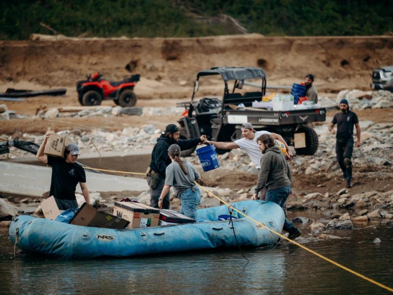 People loading supplies into an inflatable boat