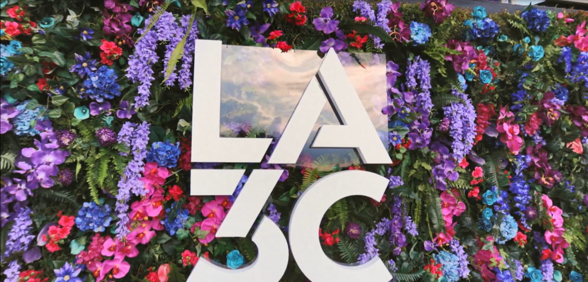 A wall of colorful flowers with LA3C letters on the front.