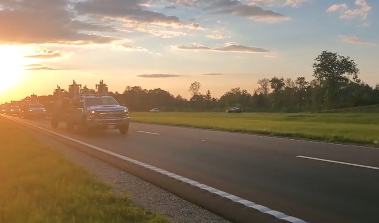 Truck on the highway with a sunset behind it