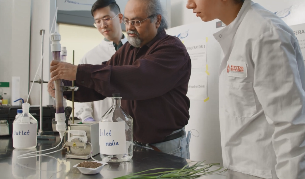 A teacher and two students working on an experiment