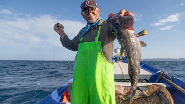 A person holding a fish