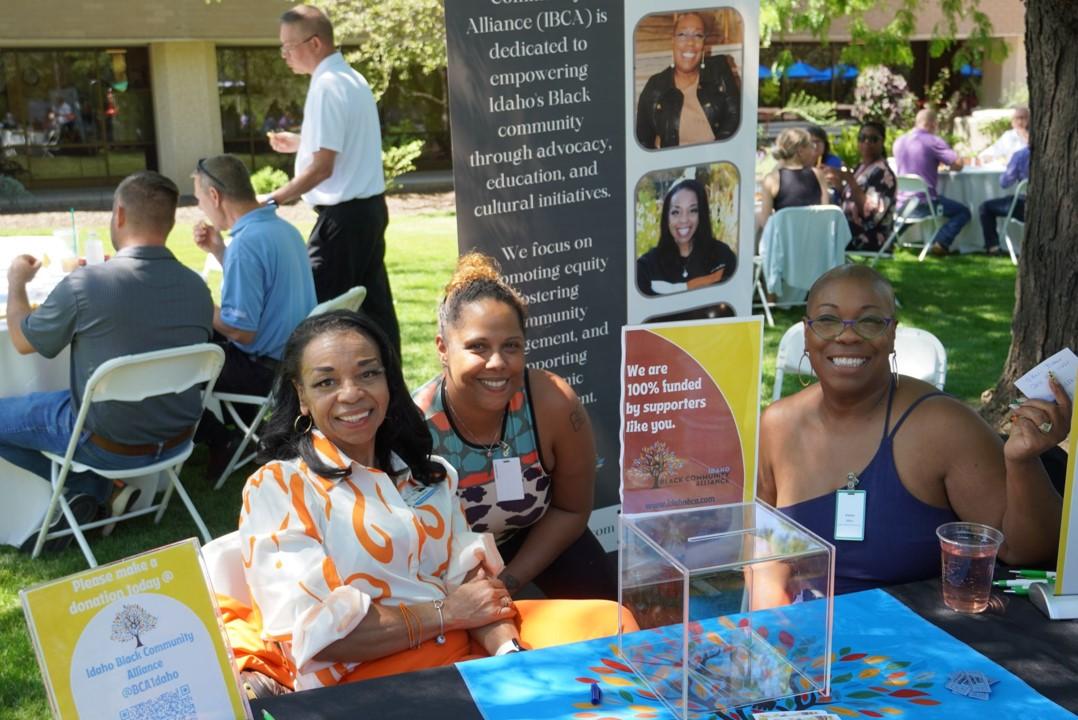 Three people sitting at booth