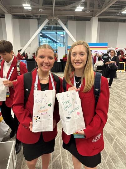 Two people posing with bags of food