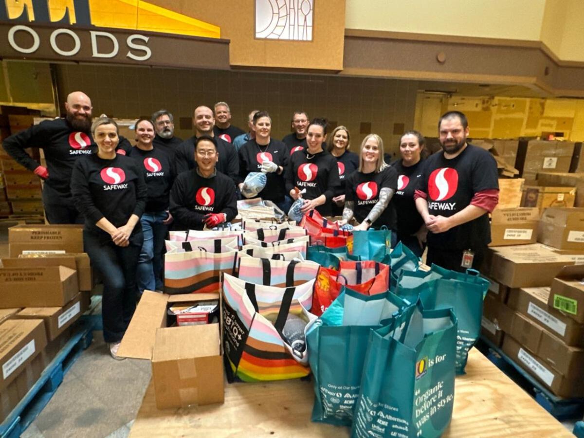 Group of people with Safeway shirts posing for picture