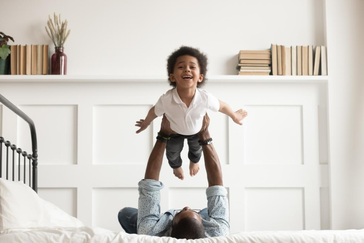 Child being held in the air by an adult.