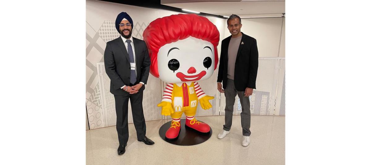 Abiman and Nick next to a large Ronald McDonald statue