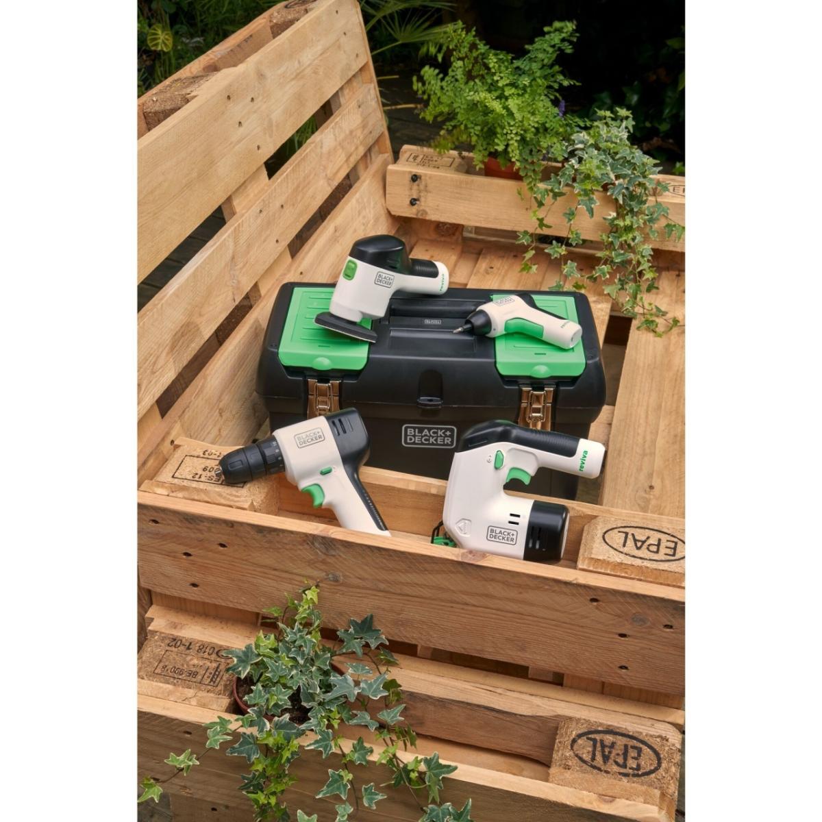 Wooden pallets stacked, white, black and green colored tools laying on top along with a carrying case.
