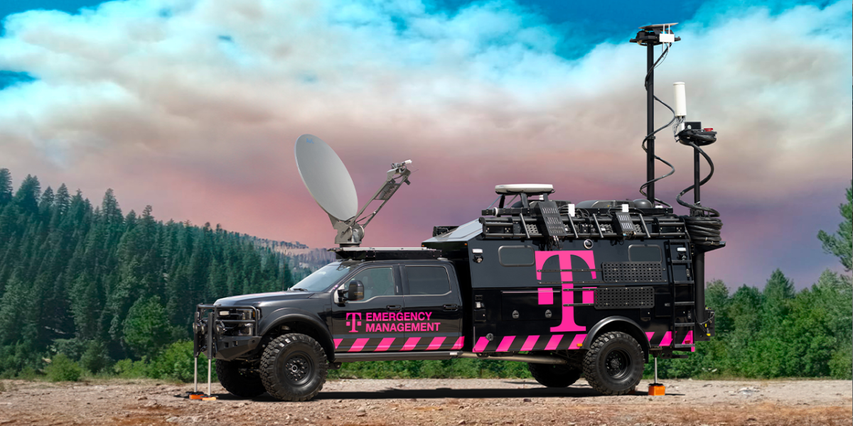 black and pink truck in front of trees and sky