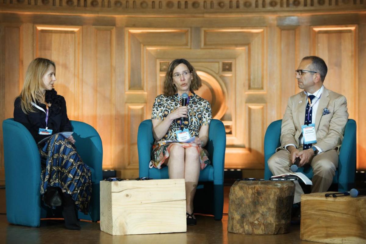 Rebecca Marmot, Leanne Geale, and Michael Goltzman speaking together on stage.