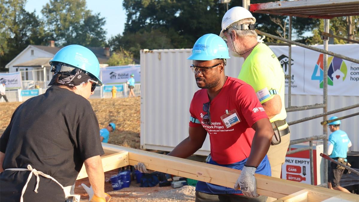 Jean Clement Nsombo, wearing a red shirt, is one of 27 homeowners whose home is under construction in the new West Charlotte neighborhood, The Meadows at Plato Price.