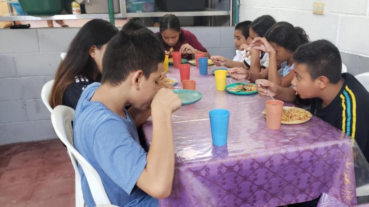Children sat at table eating food
