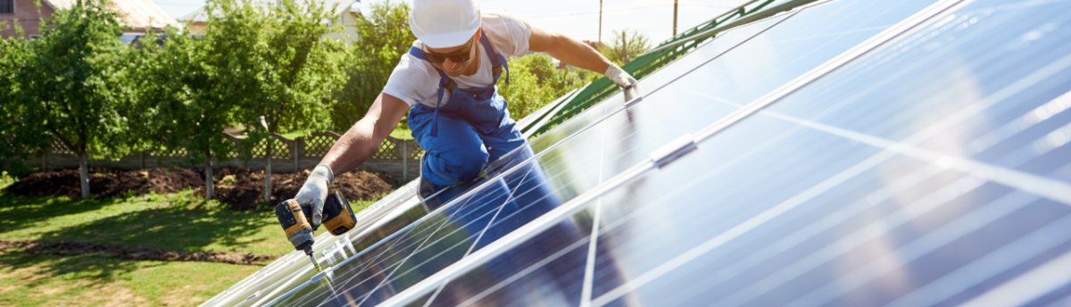 Man with hard hat at work on solar panel