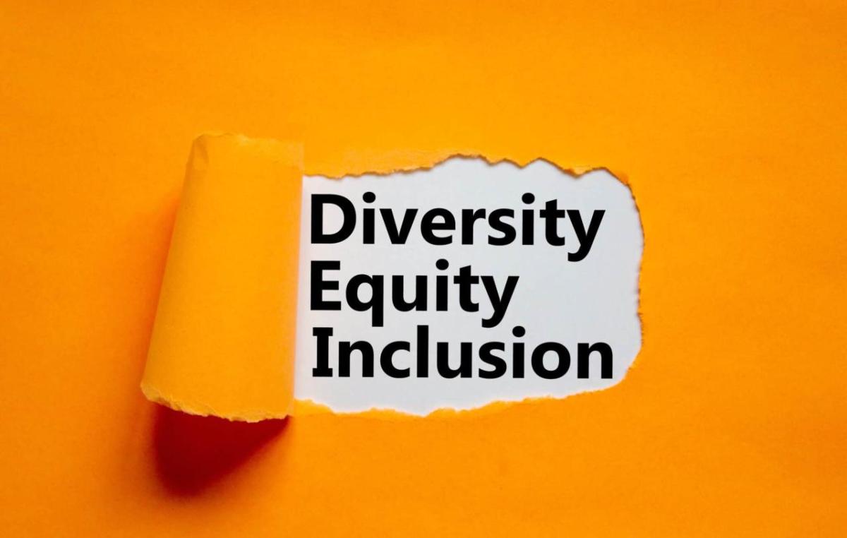 piece of orange paper pealed back in the middle, revealing text that reads "diversity equity inclusion"