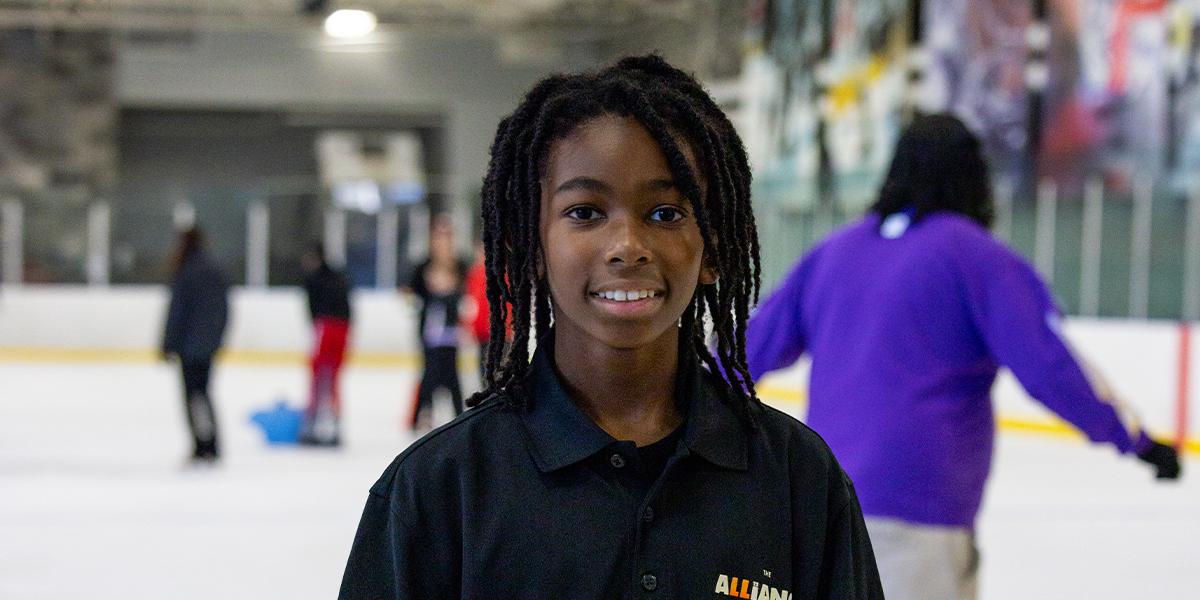 A student stops for a photo as he ice skates for the first time.