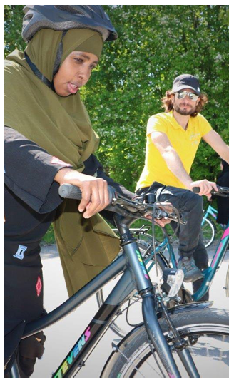 Two people riding bikes outside.