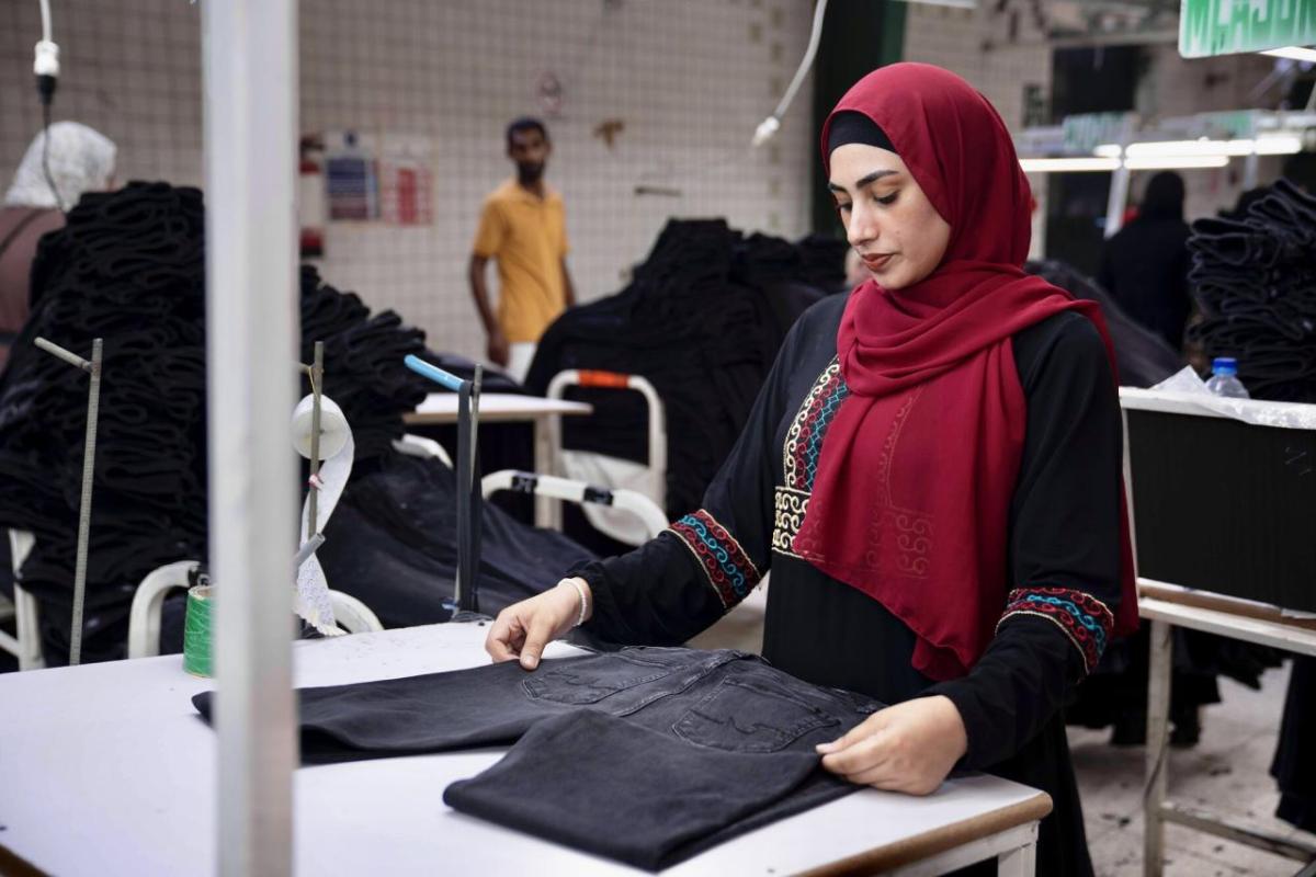 A garment worker folding a pair of jeans