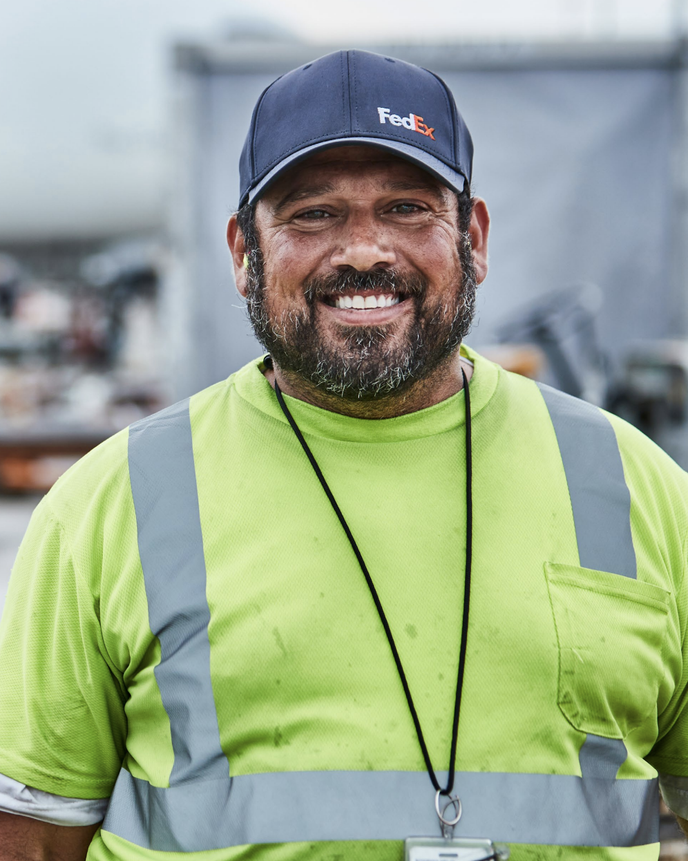 Headshot of a person wearing a FedEx hat