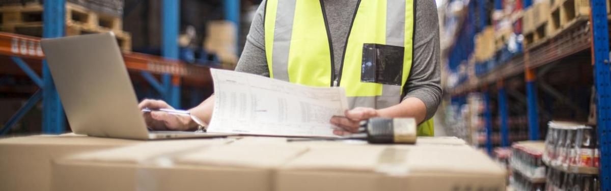 Person wearing a hi-vis jacket working on a laptop