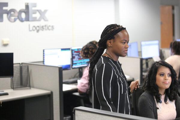 two women in a FedEx Logistics office looking off-camera