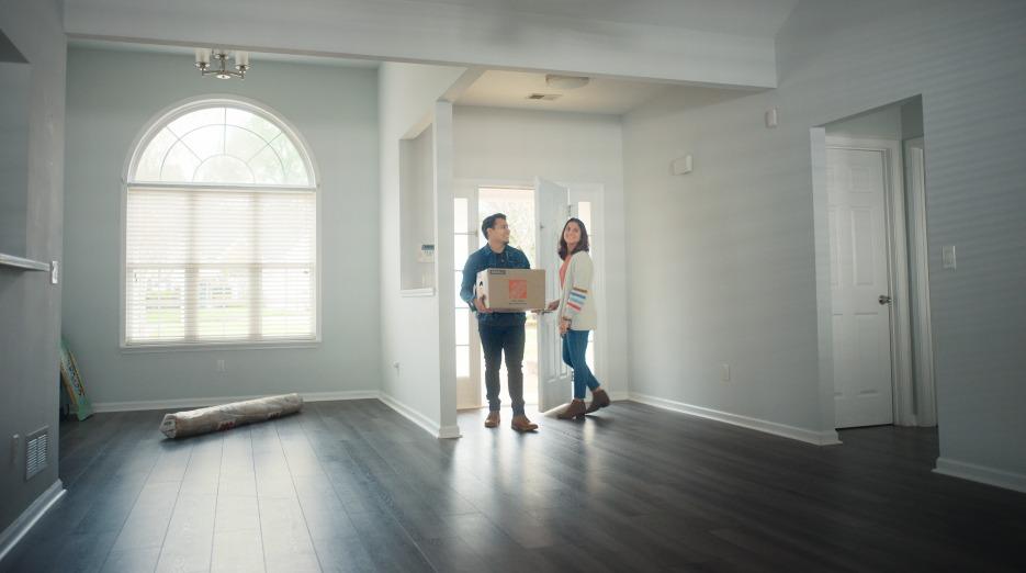 A young couple are shown moving into their new home.