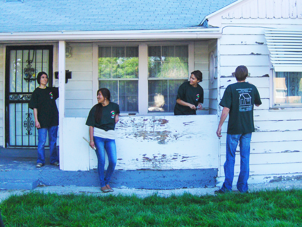 Group of YouthWorks volunteers painting house