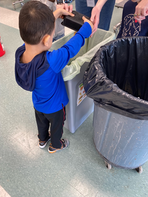 Small child emptying food waste into a bag