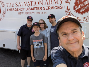 people smiling in front of Salvation Army vehicle