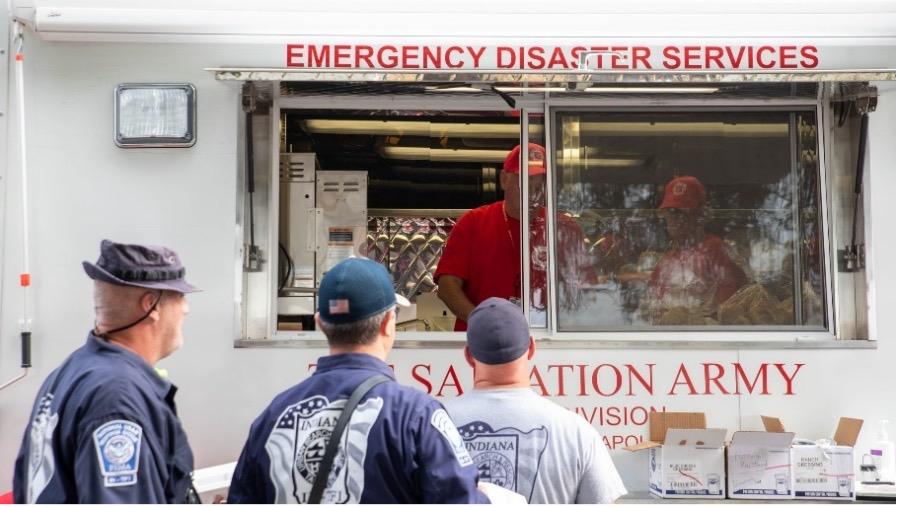 people waiting in line in front of Salvation Army vehicle