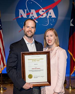 Adam Sanders and partner Kasey Wilson with the award Sanders received from NASA.