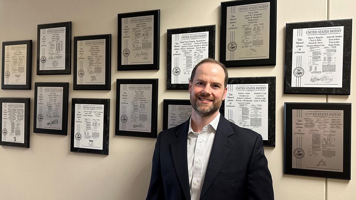 Adam Sanders in front of the patent wall outside the Dexterous Robotics Laboratory at NASA's Johnson Space Center in Houston. Sanders was awarded 11 patents while working at NASA.