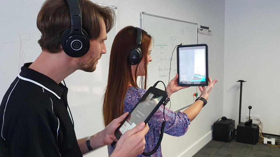 two people with headsets on using a computer