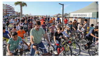 A large group of children and adults on bikes outside.