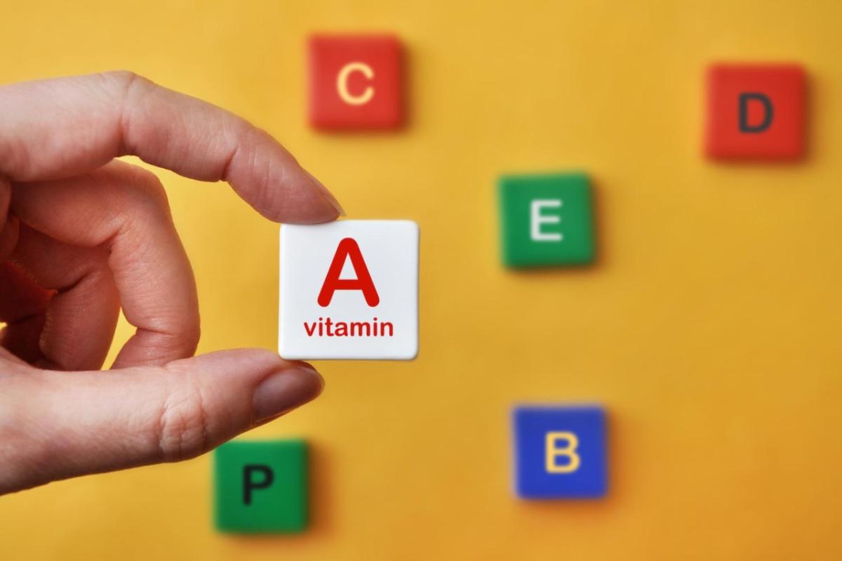 person holding up a block reading "A vitamin"