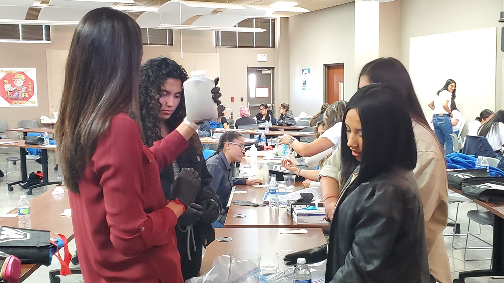 Students building water filters in a classroom setting.