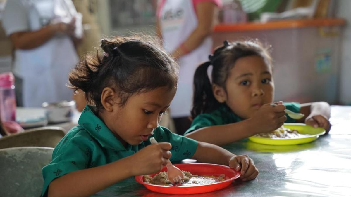 Two children eating at a table.