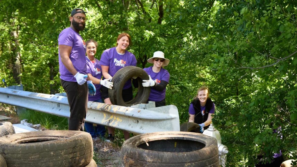 Volunteers pulling used tires out of the forested area.