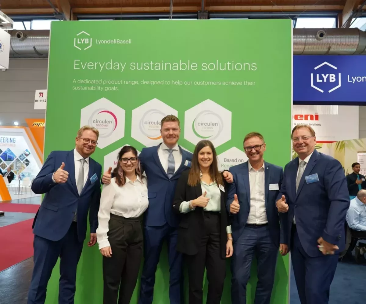 A group of people stood together in front of a LYB event backdrop 