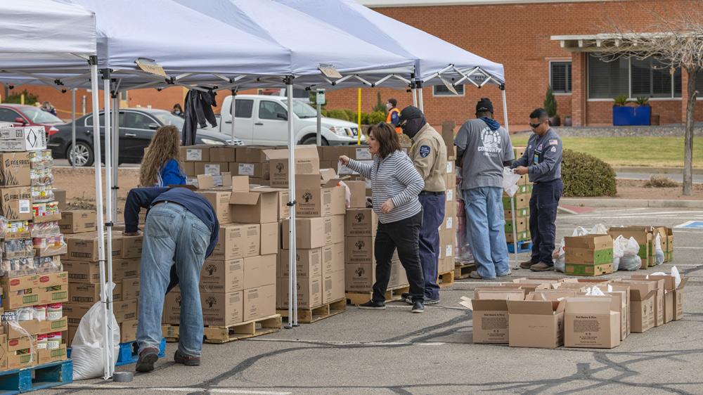 Food distribution event with boxes under tents set up outside