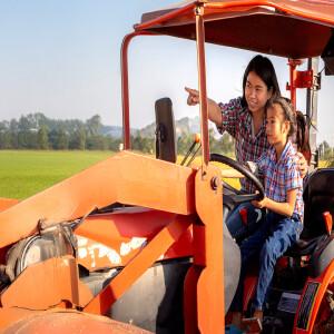 An adult and a child on a tractor