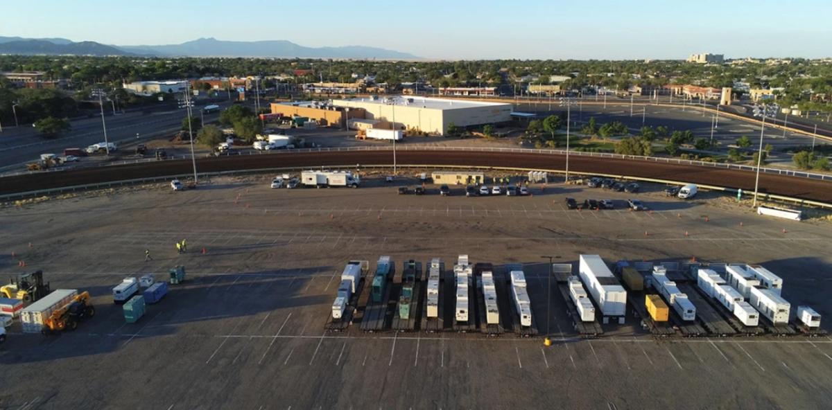 a large parking lot with trailers loaded with large generators